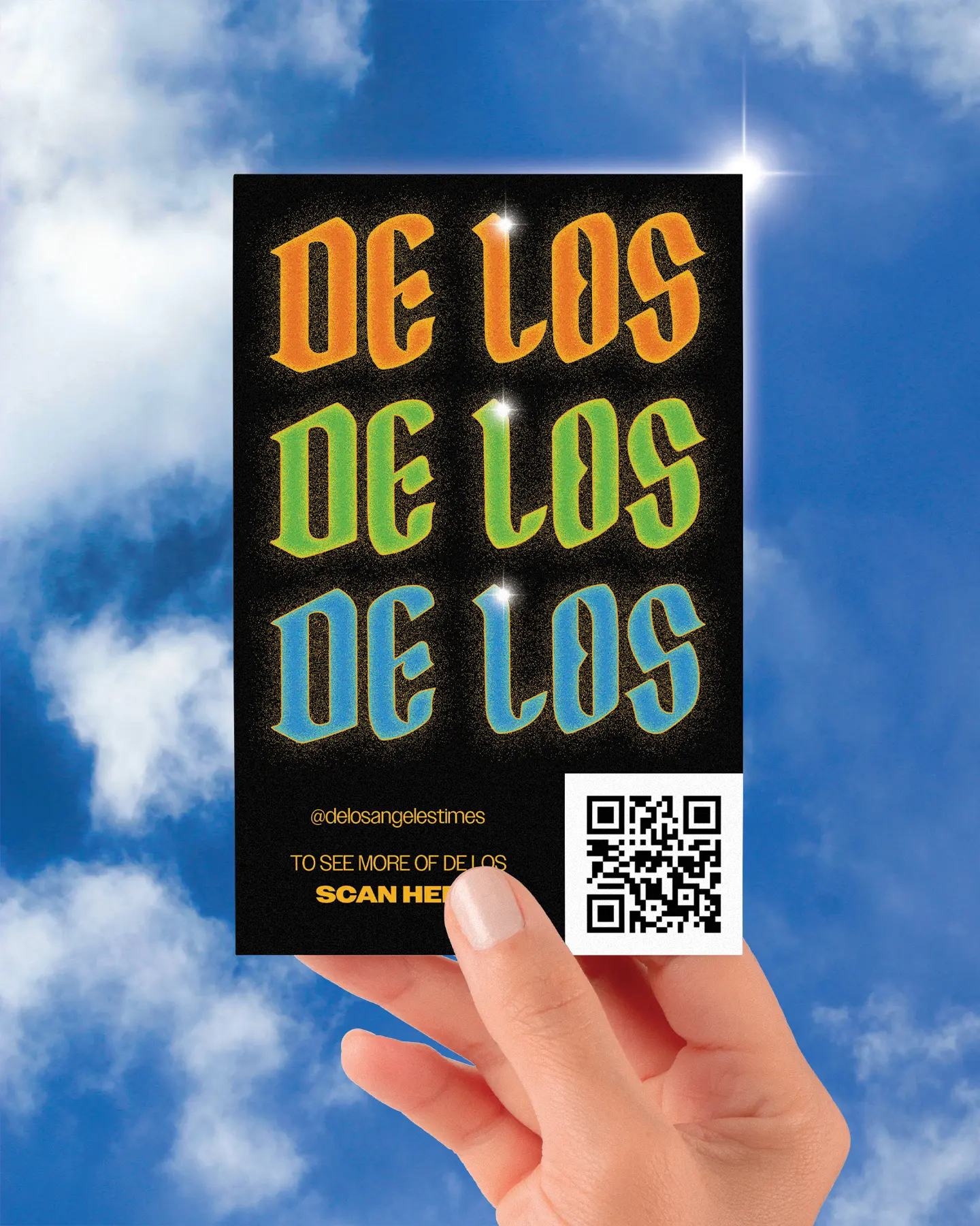 A hand holding a postcard up to the sky