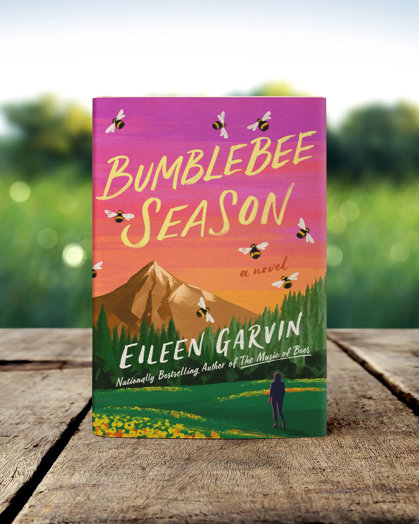 Book standing on table in a grassy field